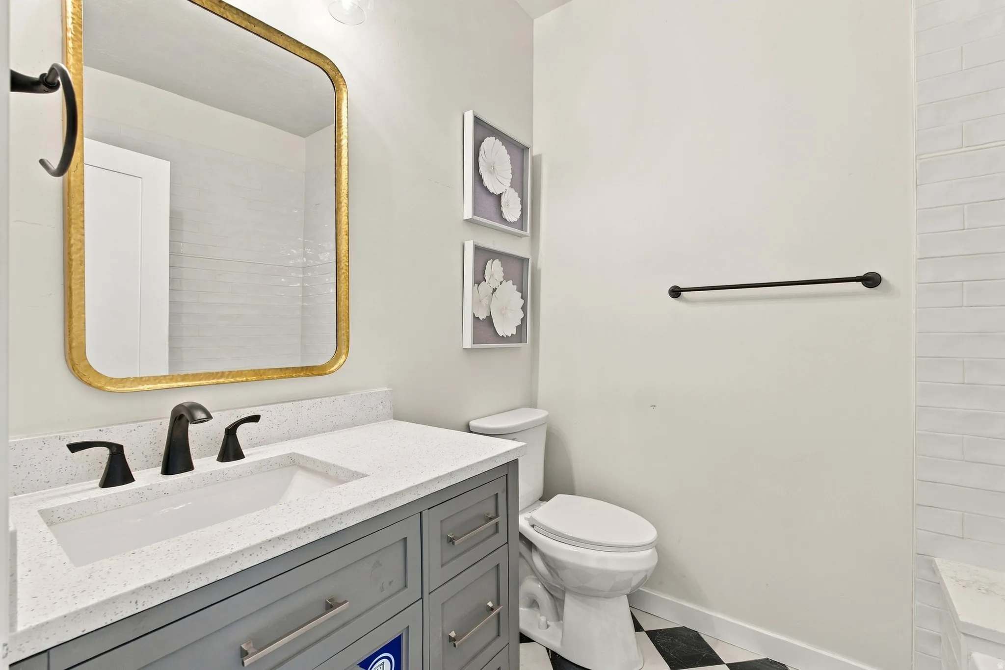 Vanity with a light-colored countertop, undermount sink, and matte black faucet