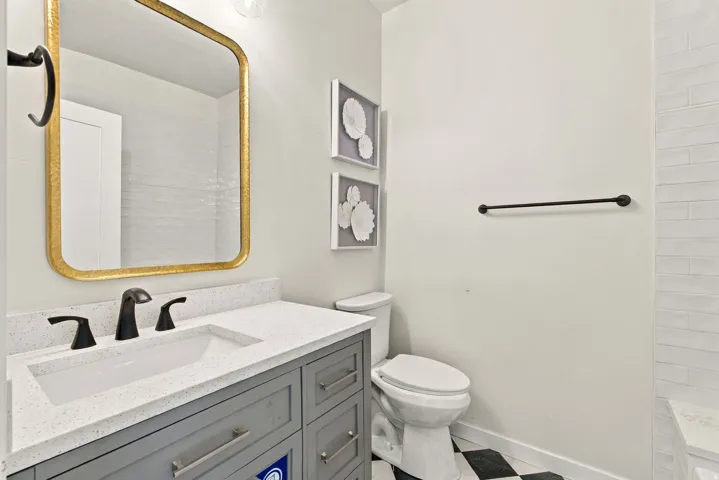 Vanity with a light-colored countertop, undermount sink, and matte black faucet