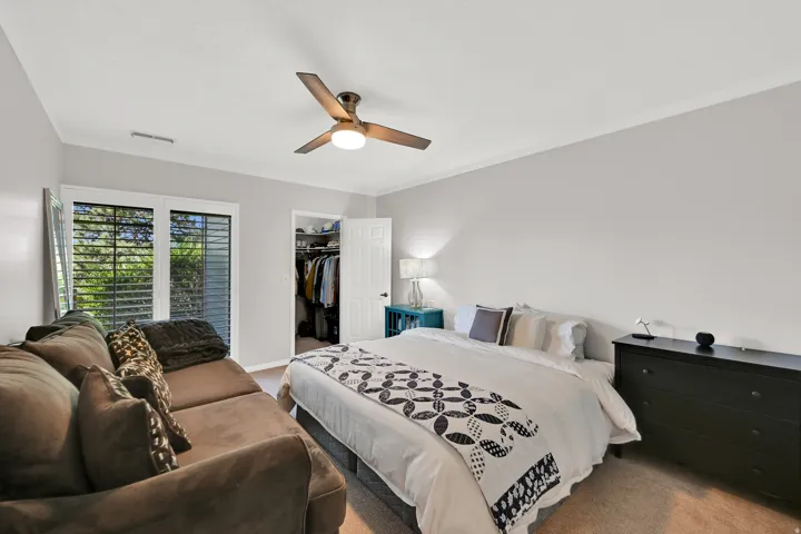 Recessed lighting, ceiling fan with integrated light, built-in closet with shelving, and window with louvered shutters