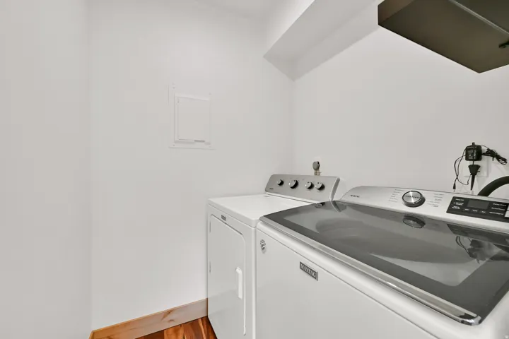 Laundry area featuring wood-finish flooring and white walls