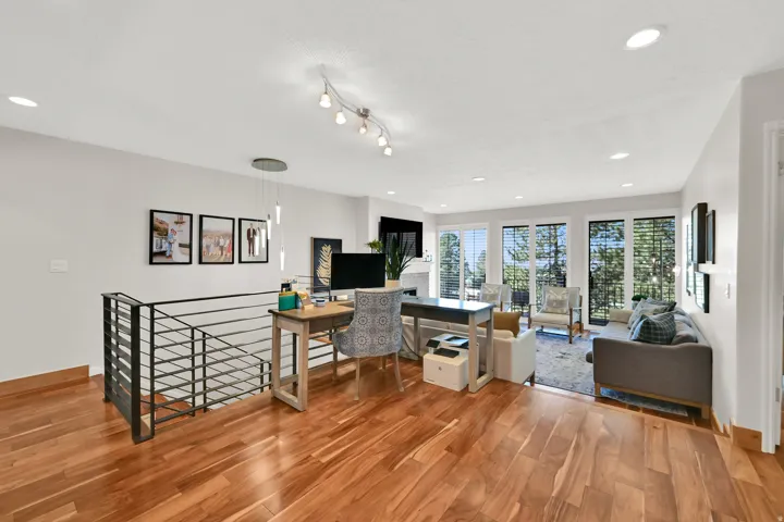 Hardwood flooring throughout, modern metal railing, recessed lighting, and track lighting