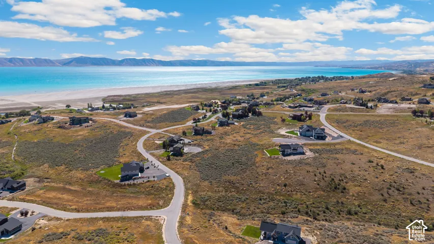 Expansive land parcels with paved roads and distant water and mountain backdrops