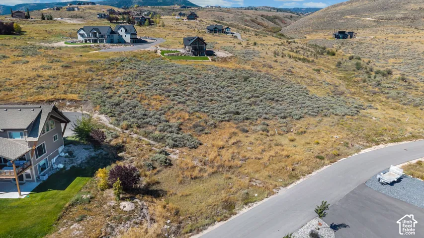 Expansive landscape featuring rolling hills, natural vegetation, and paved roadways