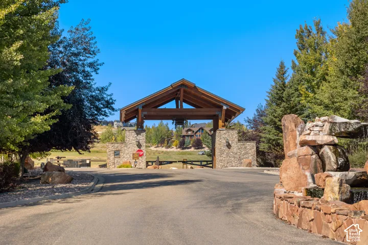 Gated entry with stone columns and wood beam overhead
