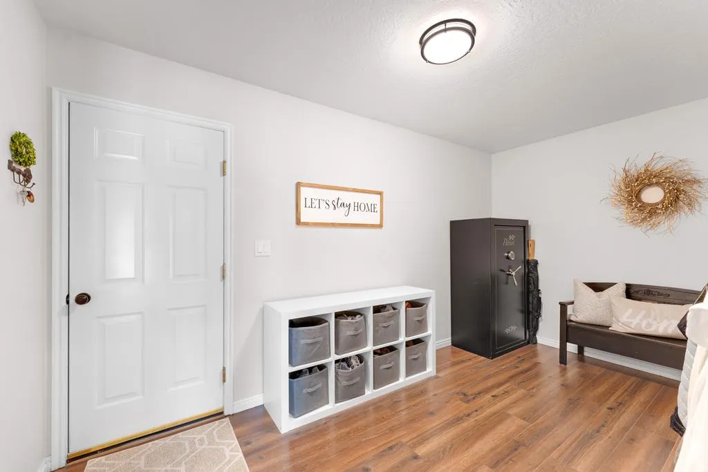 Wood-finish flooring with light-toned walls and a flush-mount ceiling light fixture