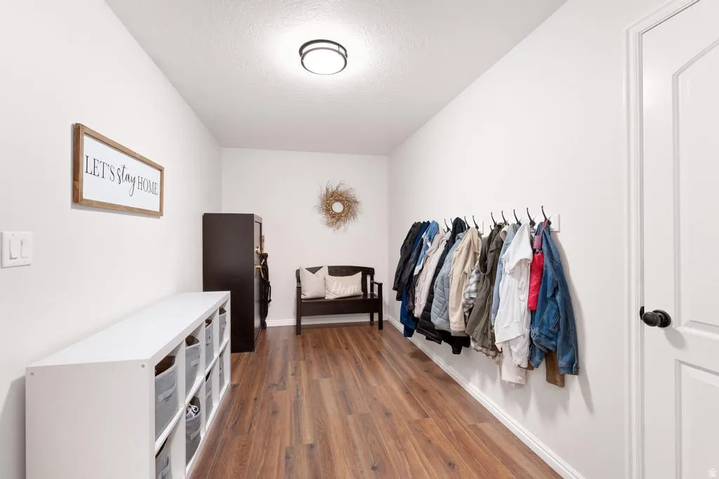 Recessed ceiling light fixture, wood-finish flooring, white wall paint, and white trim