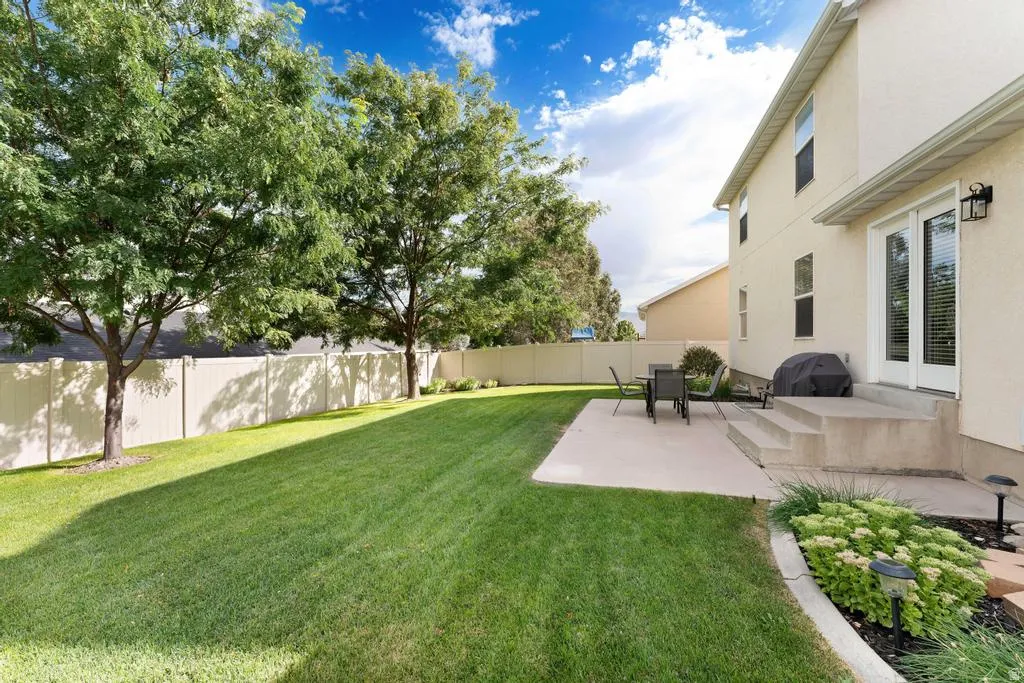 Expansive rear yard featuring a manicured lawn and mature trees