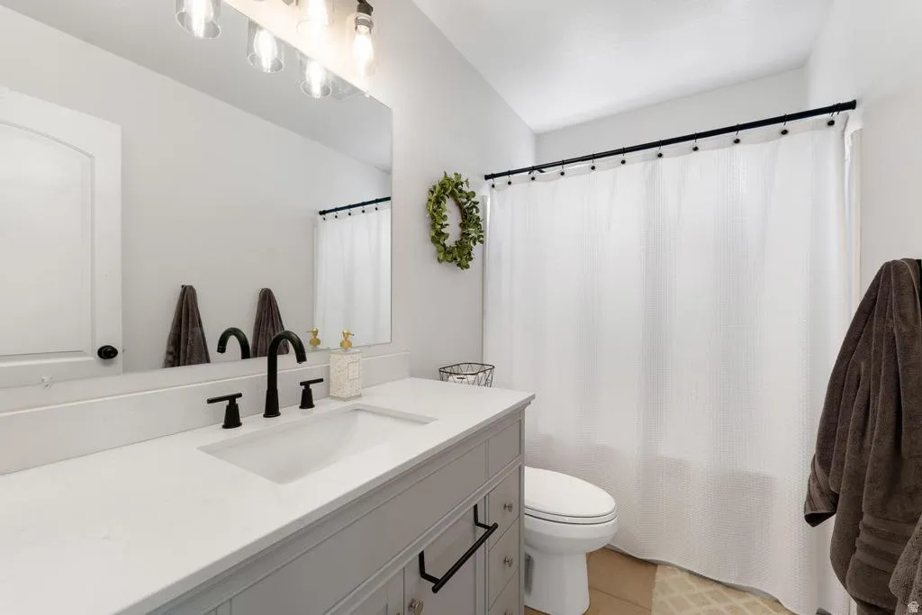 White vanity with an integrated rectangular sink, matte black faucet, and light-toned countertop