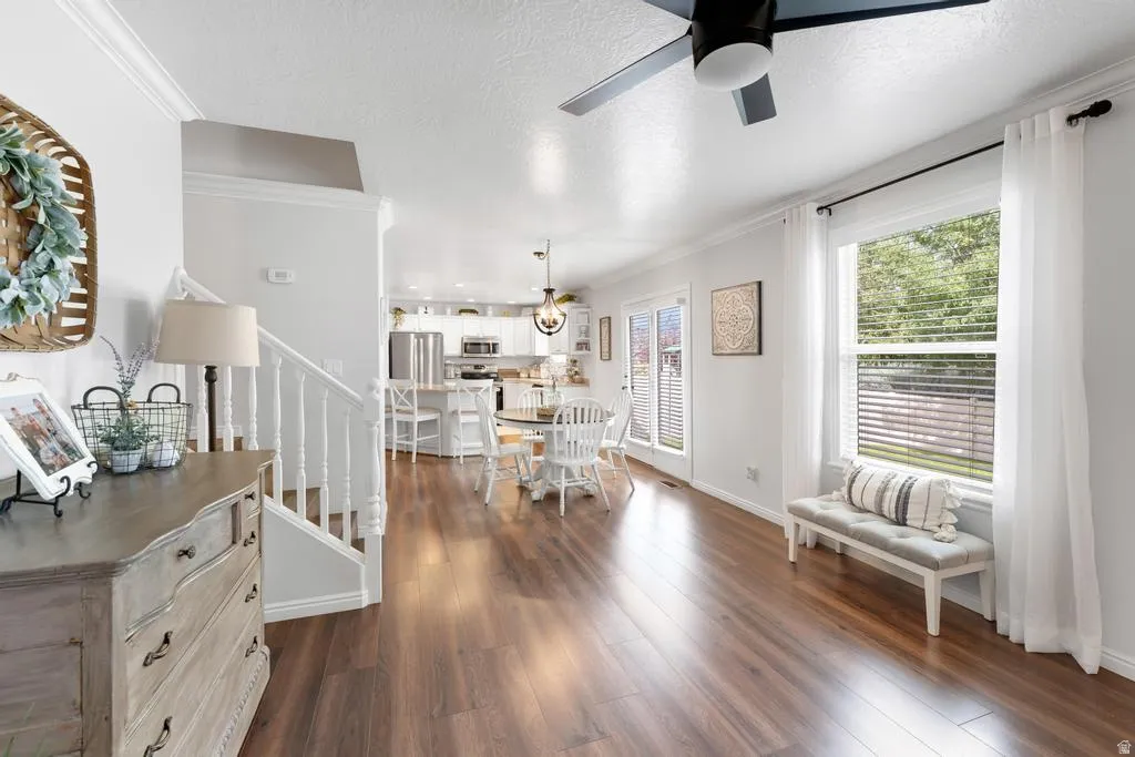 Wood-finish flooring, white walls, and a ceiling fan with integrated lighting