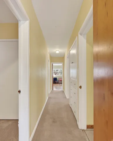 Hallway with neutral carpeting, built-in storage drawers, and recessed lighting
