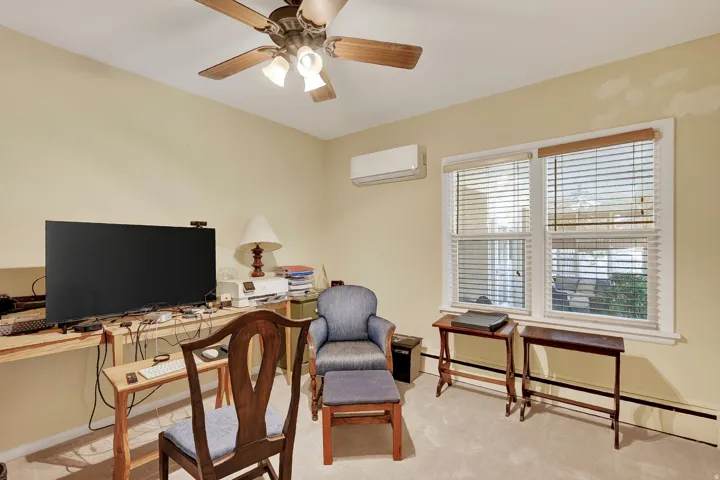 Wall-mounted split system, wood-finish ceiling fan, and double window with blinds