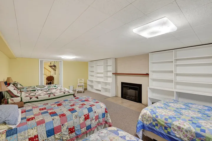 Room featuring a built-in fireplace with a dark surround and mantel, two large built-in shelving units, and carpet flooring