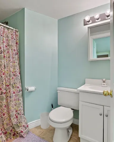 Bathroom with a single vanity, integrated sink, and white cabinetry