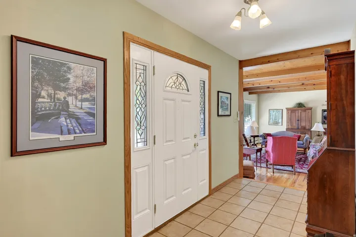 Entryway featuring a white door with decorative glass panels, light-colored tile flooring, and a flush mount light fixture
