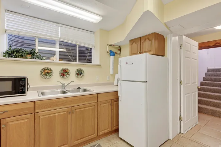 Dual basin stainless steel sink, wood-finish cabinetry, and neutral countertops