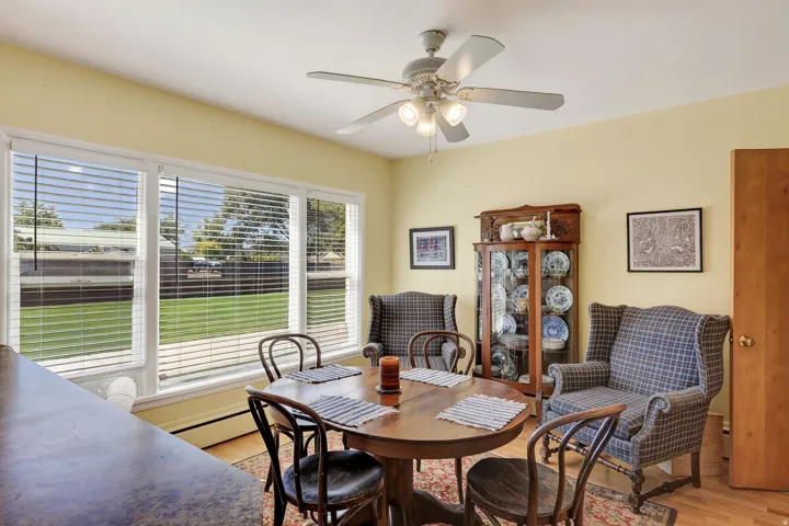 Room with multiple windows, a ceiling fan with integrated lighting, and a built-in display cabinet