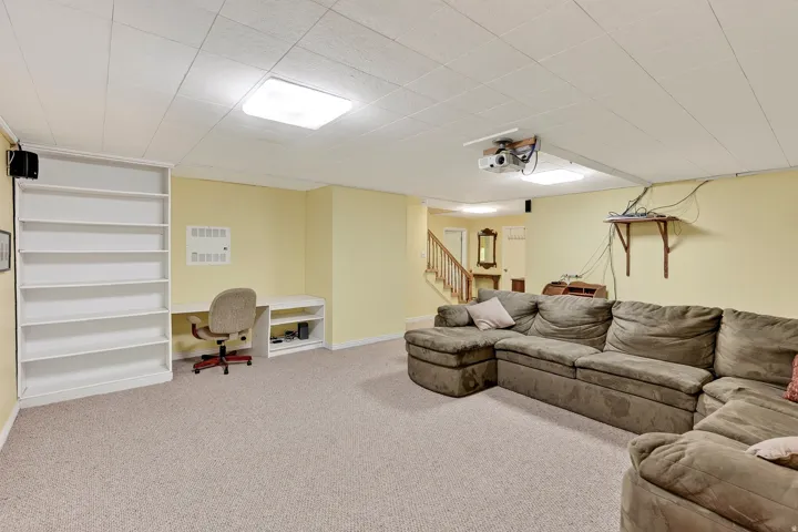 Built-in shelving, integrated desk, staircase access, and recessed ceiling lighting