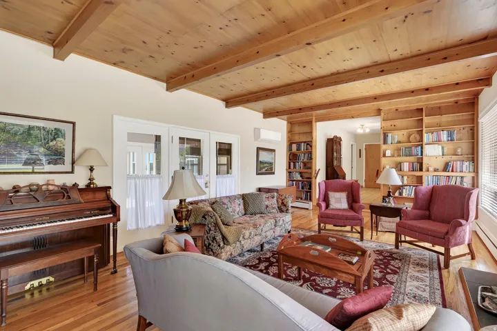 Wood-finish flooring with exposed ceiling beams and recessed lighting