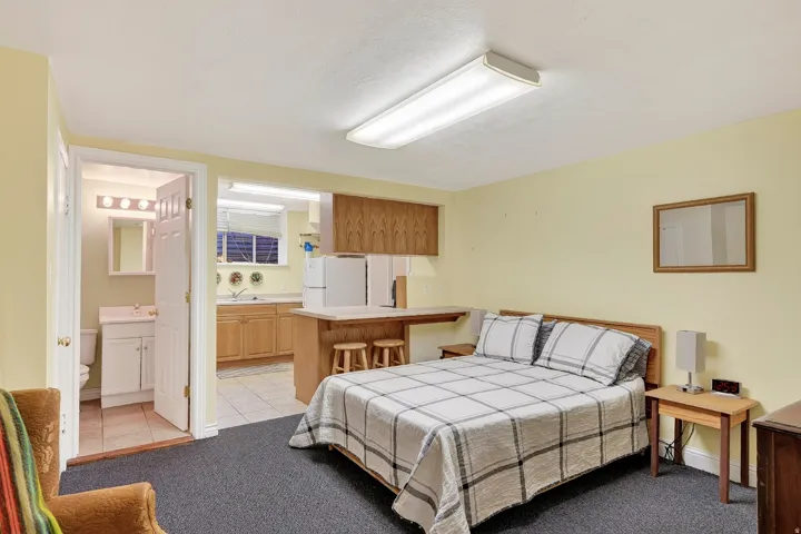 Combined living and sleeping area with a full kitchen, built-in breakfast bar, and an attached bathroom