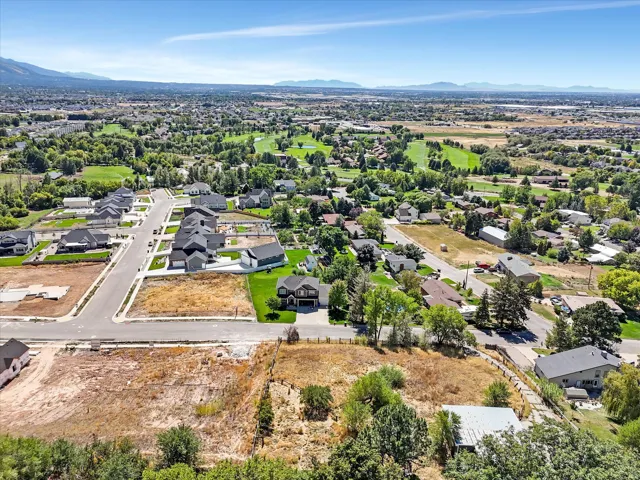 Aerial perspective showcasing a residential area with undeveloped land parcels and distant mountains
