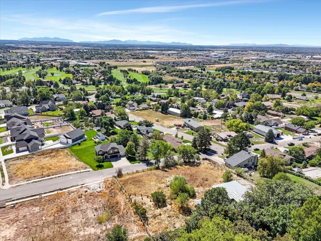 Expansive neighborhood setting with established homes, mature trees, and mountainous background