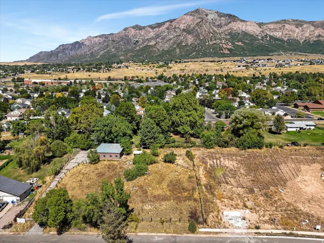 Mountain backdrop, residential area, and a structure with a light-colored roof