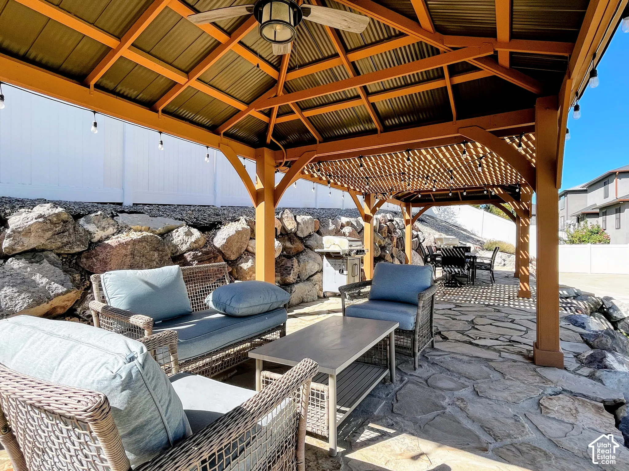 Stone patio with a wood-frame gazebo and corrugated metal roof