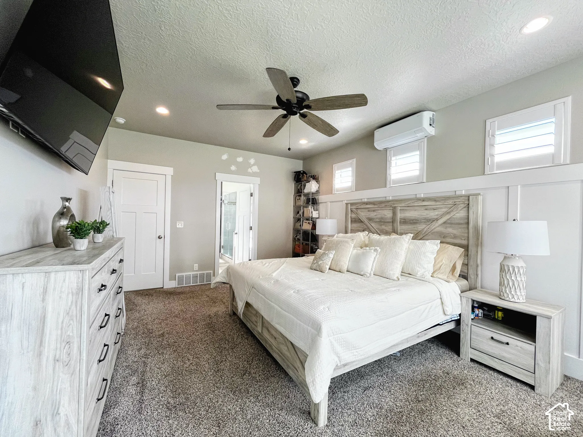 Recessed ceiling lighting, ceiling fan, carpet flooring, plank-style wainscoting, and white interior doors