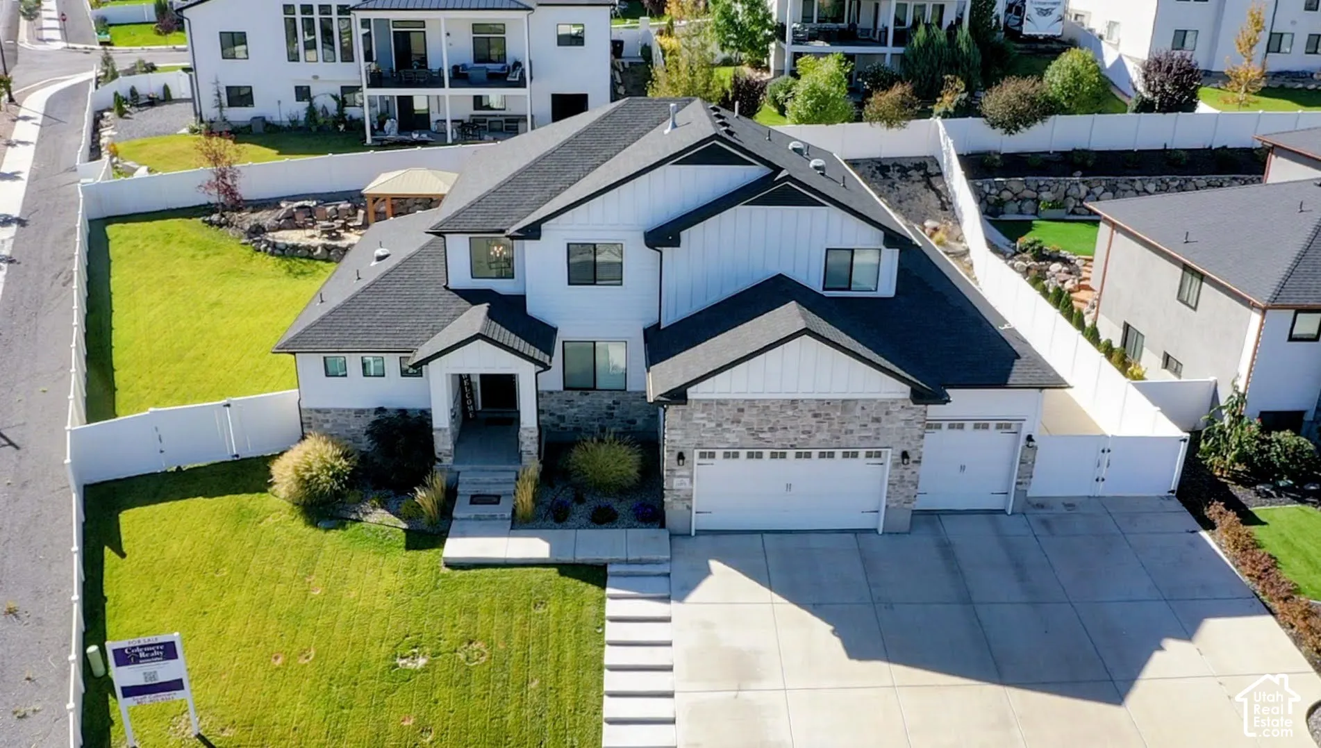 Contemporary exterior with dark roof, white siding, and stone accents