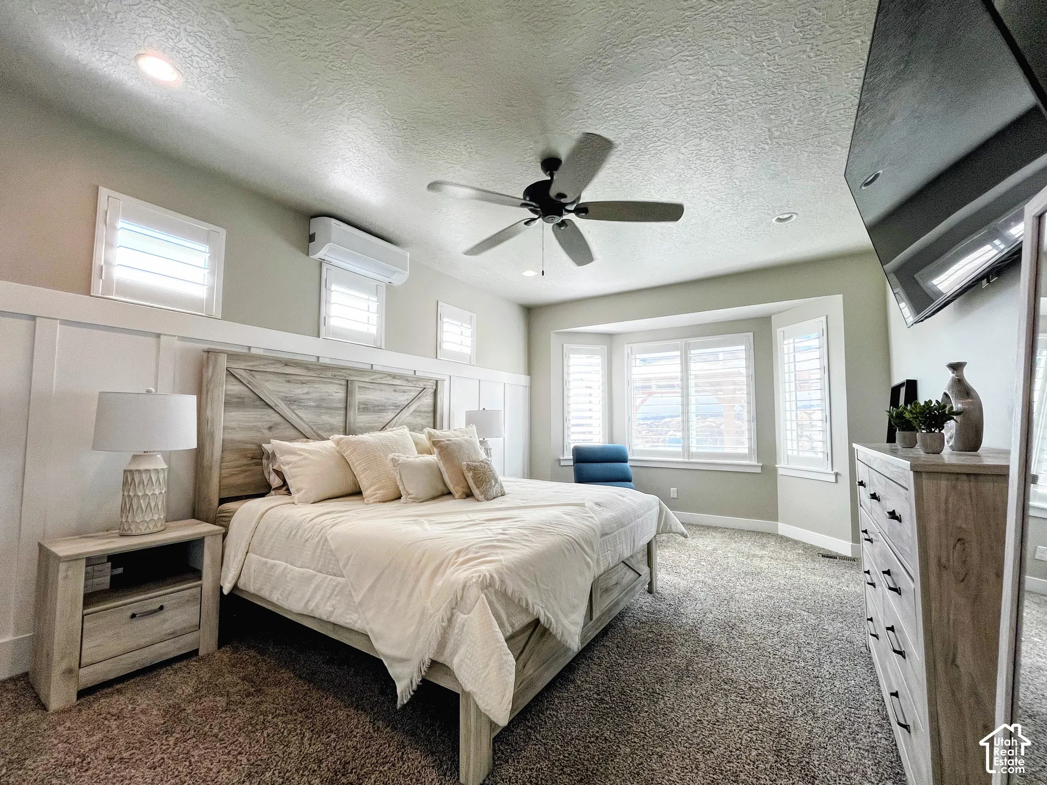 Recessed lighting, ceiling fan, bay window, board and batten wall treatment, and light-filtering window treatments