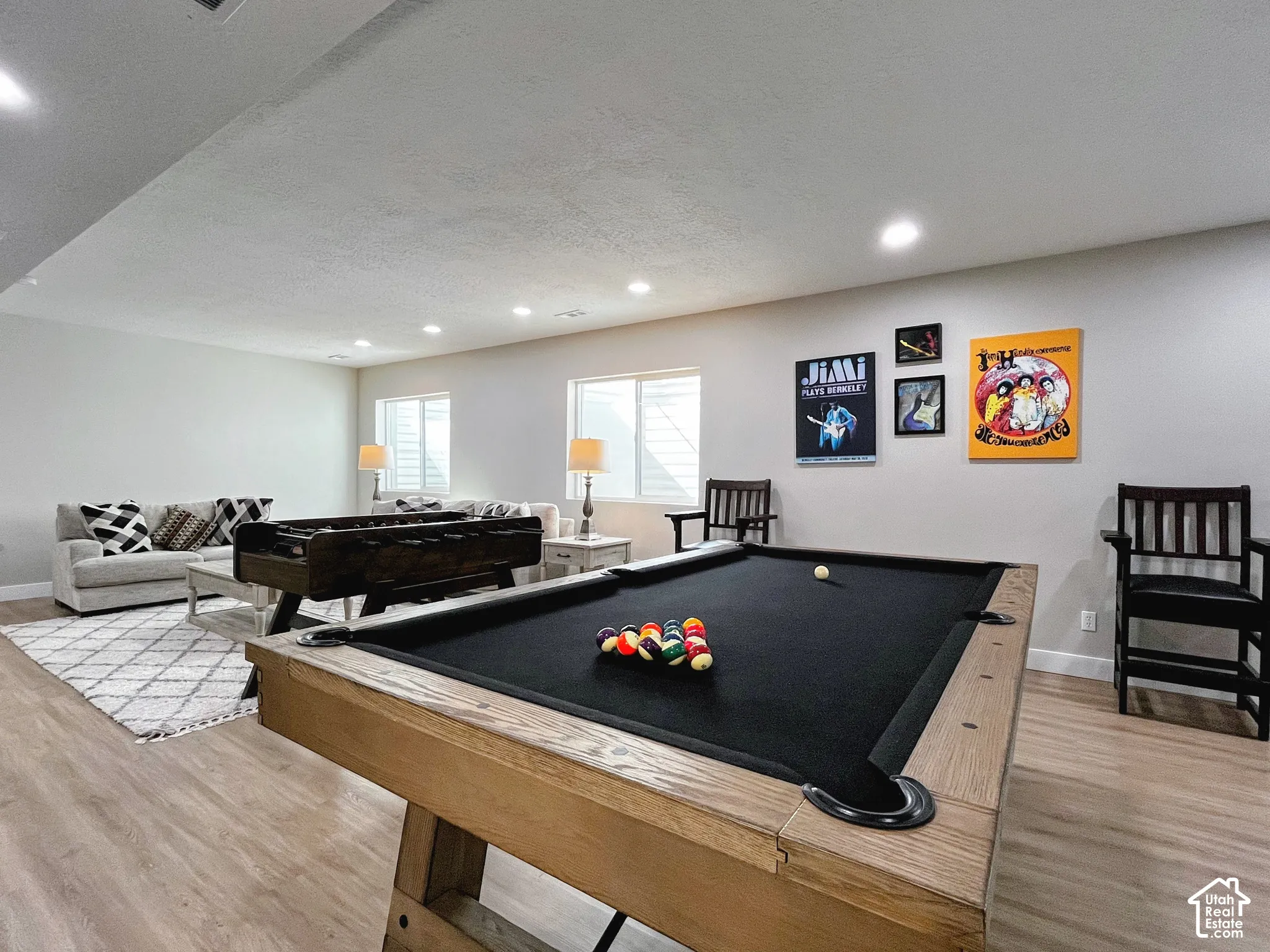 Spacious recreation area featuring wood-finish flooring and recessed lighting