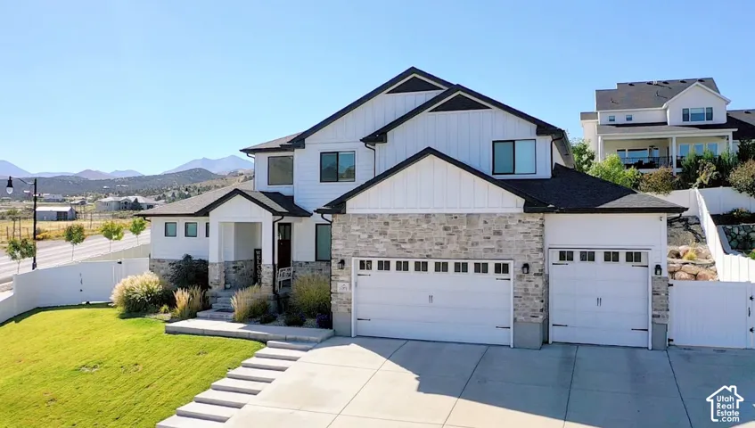 Contemporary two-story residence with white vertical siding and stone accents