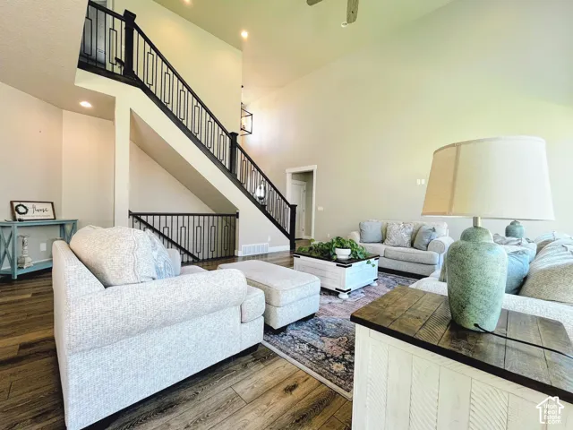 Vaulted ceilings, wood-finish flooring, staircase with custom metal railing, recessed lighting, and a contemporary chandelier