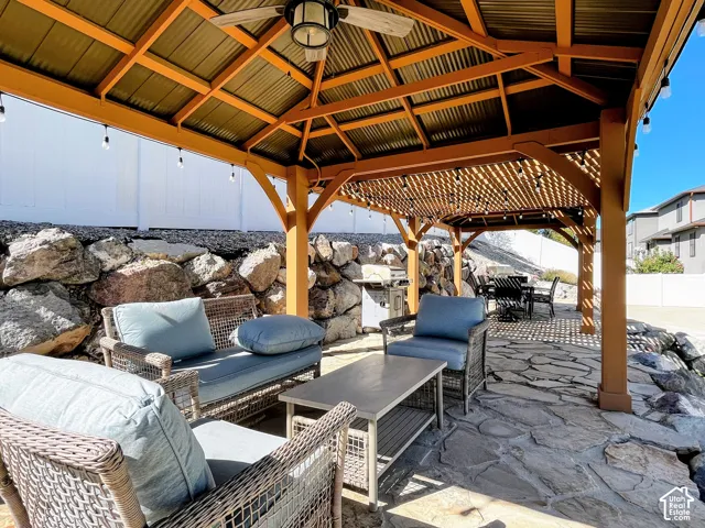 Stone patio with a wood-frame gazebo and corrugated metal roof