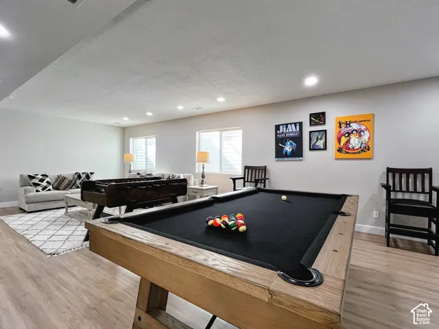 Spacious recreation area featuring wood-finish flooring and recessed lighting