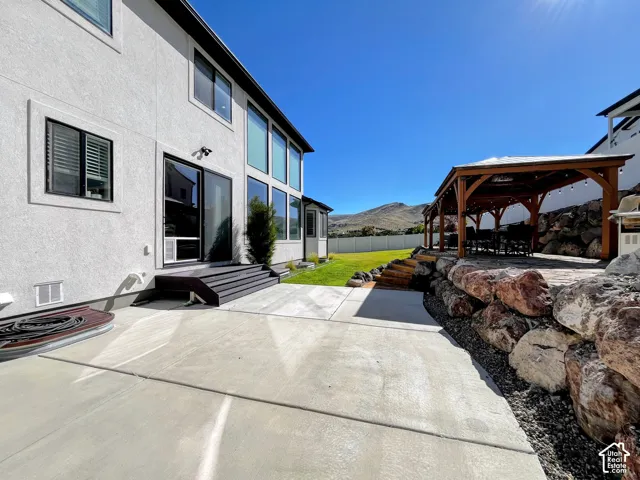 Concrete patio with tiered dark-stained wood steps leading to a sliding glass door