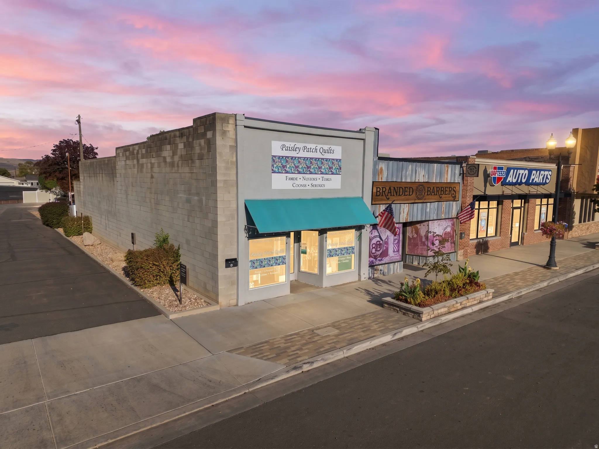 Commercial building with a prominent storefront, teal awning, and an adjacent block wall structure