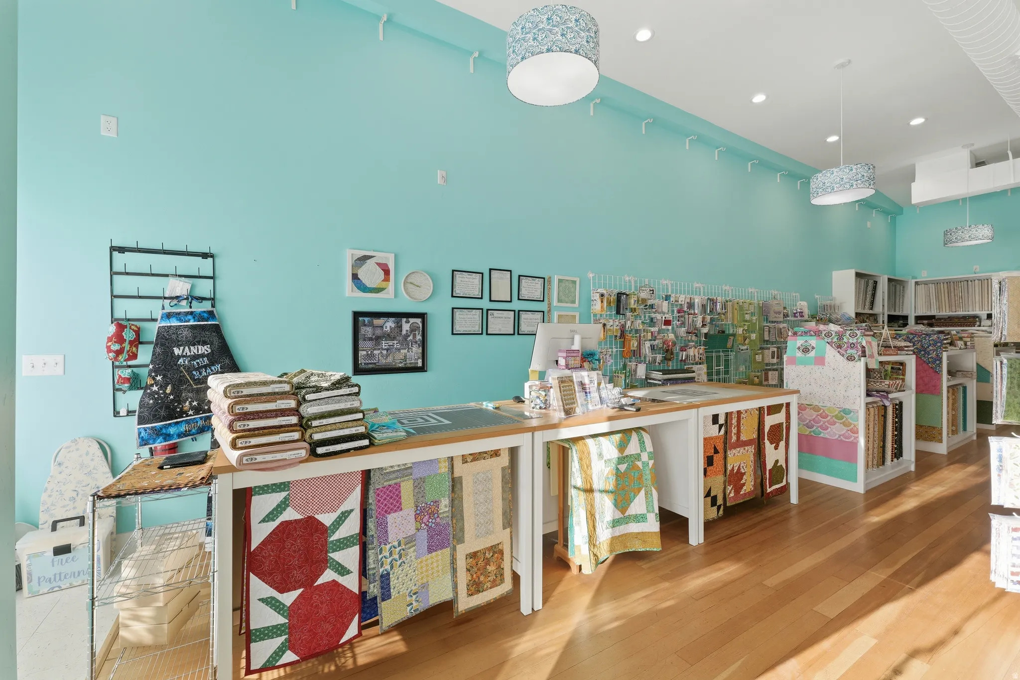 Hardwood flooring, track lighting, pendant light fixtures, and light blue walls