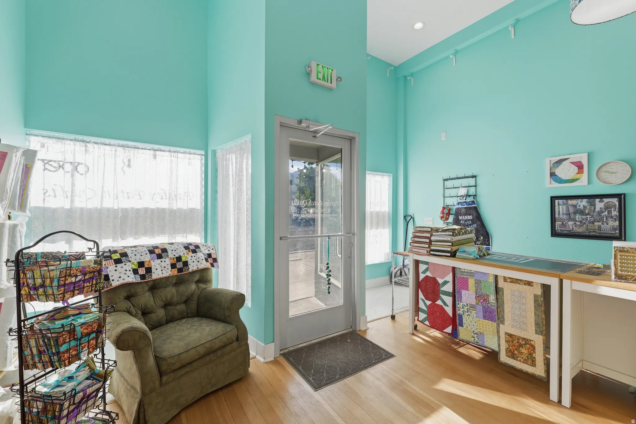 Hardwood flooring, high ceilings, large windows with privacy coverings, recessed lighting, and a prominent entry door