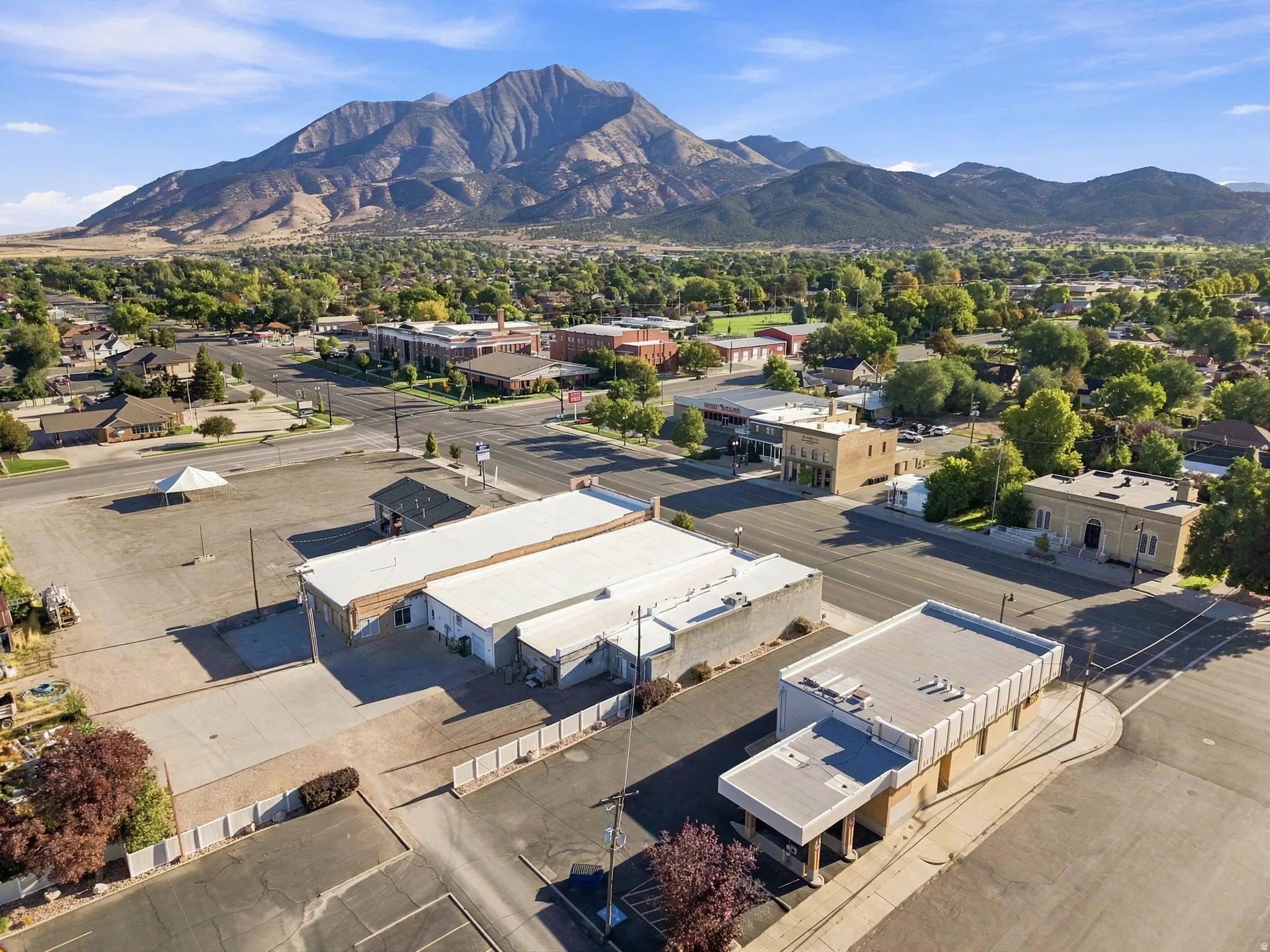 Expansive commercial property featuring multiple buildings, paved parking areas, and street frontage