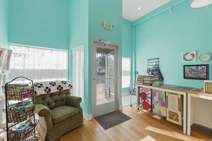 Hardwood flooring, high ceilings, large windows with privacy coverings, recessed lighting, and a prominent entry door