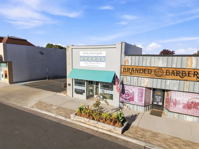 Commercial storefront with a teal awning and stone planters
