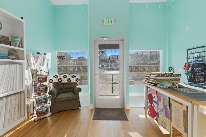 Hardwood-finish flooring, high ceilings, built-in shelving, expansive storefront windows, and a glass-paneled entry door