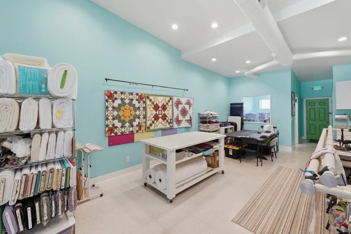 Vaulted ceiling with exposed ductwork, recessed lighting, light-toned flooring, and a green paneled door