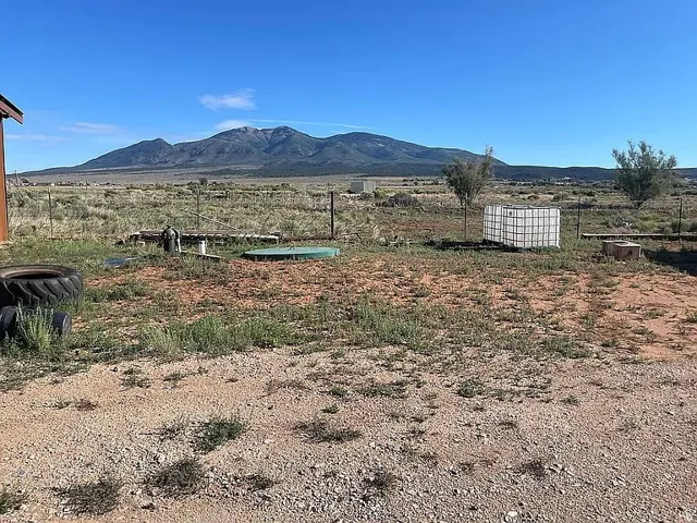 Expansive outdoor space featuring a mountain backdrop and a partial structure