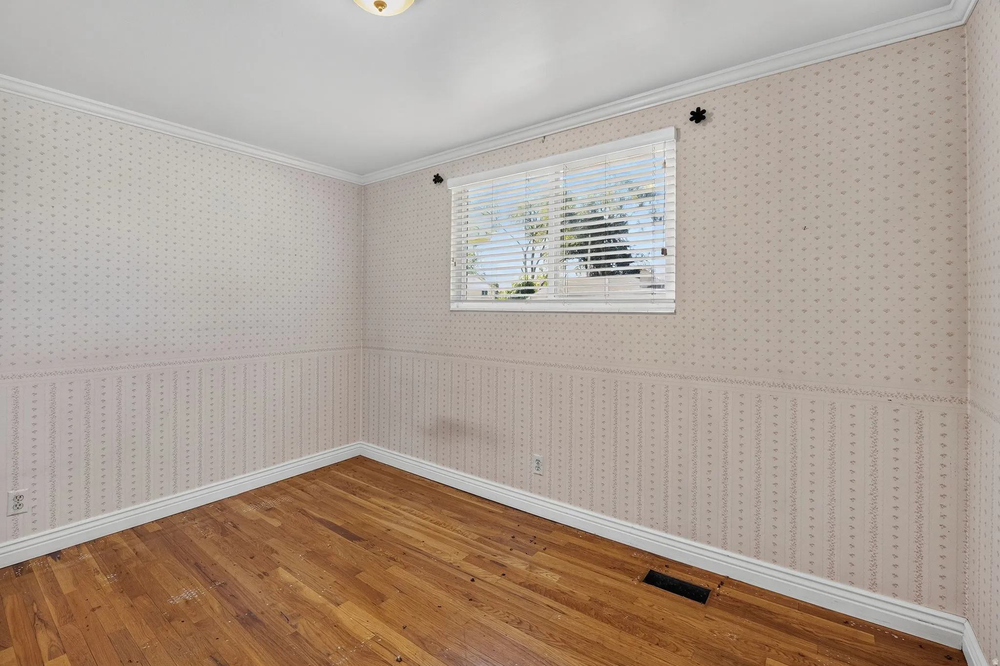 Wood-finish flooring, white window blinds, and a built-in ceiling light fixture