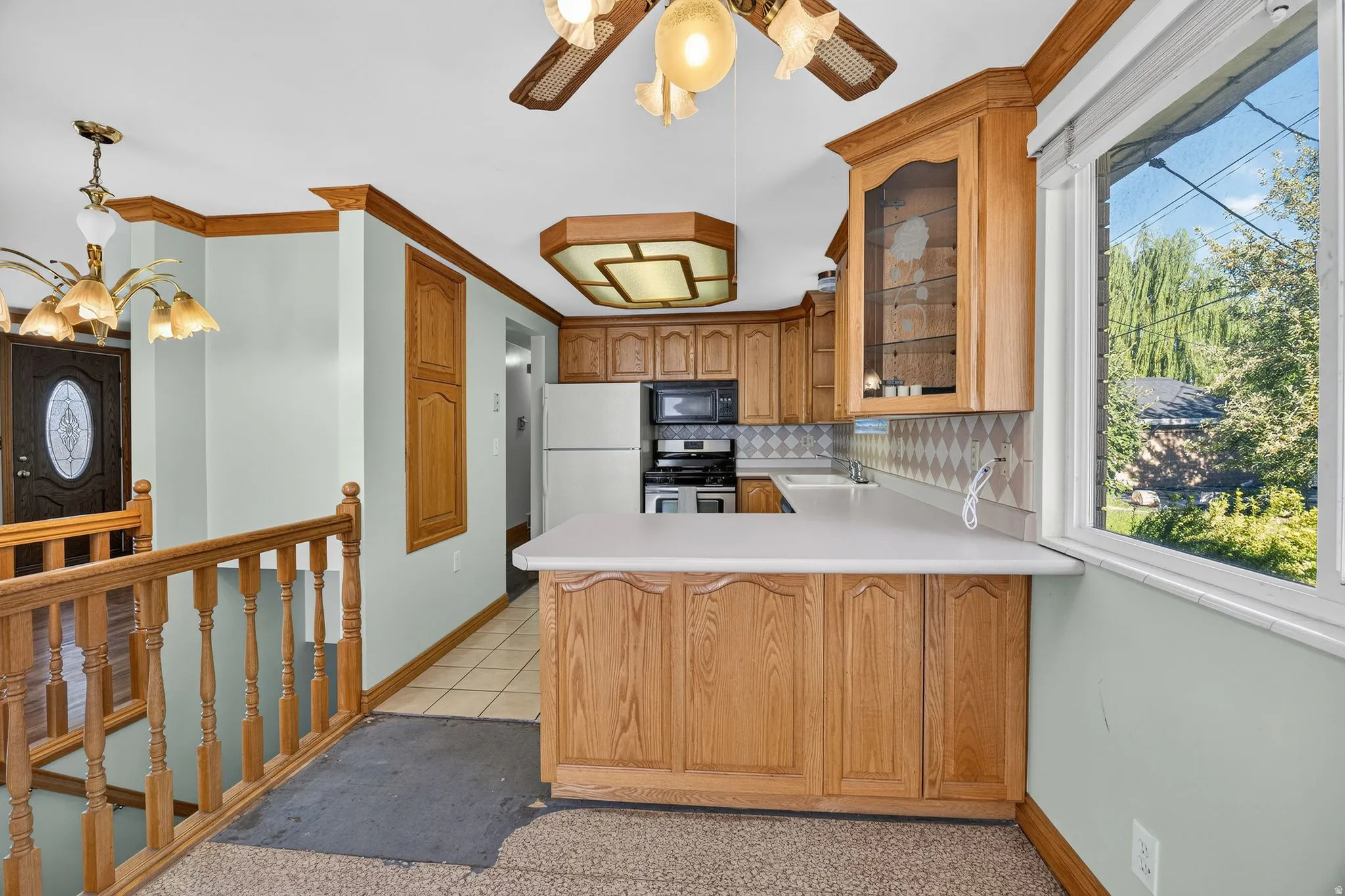 Kitchen featuring red oak wood cabinetry, a white countertop, and a tiled backsplash