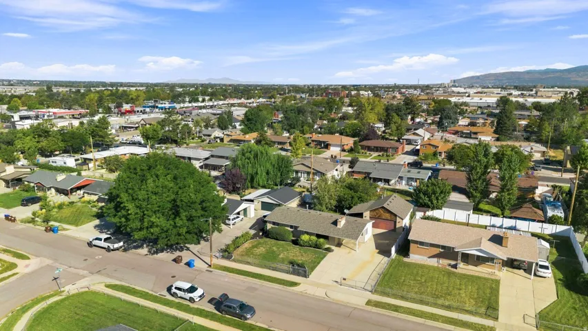 Residential neighborhood with mature trees and a clear mountain backdrop