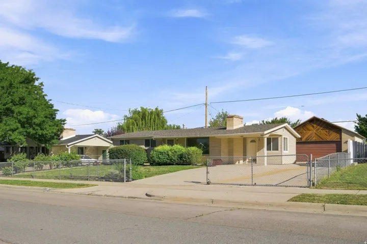 Front exterior featuring a fenced yard, mature landscaping, RV storage and entertaining space