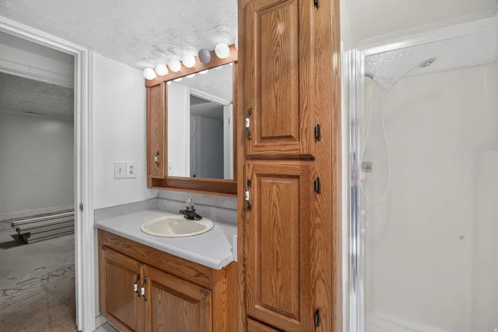 Vanity with a laminate countertop, built-in medicine cabinet, and wood-finish cabinetry